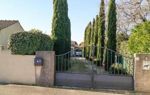 a gate to a house with trees behind it at 3 Bedroom Nice Home In Sanilhac-Sagries in Sanilhac-et-Sagriès +13 photos