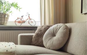 a pillow on a couch with a bike in a window at 3 Bedroom Nice Home In Stavenisse in Stavenisse