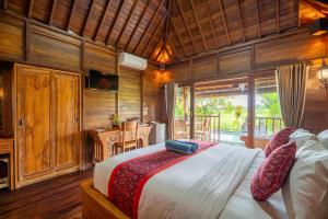 a bedroom with a large bed in a room at Villa Kayu By Mardika in Ubud