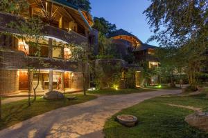 ウダワラウェにあるGrand Udawalawe Safari Resortの夜の灯りの庭付きの家