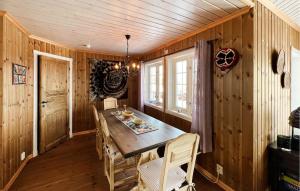 a dining room with a wooden table and chairs at Nice Home In Nord-Torpa With Sauna in Nord Torpa