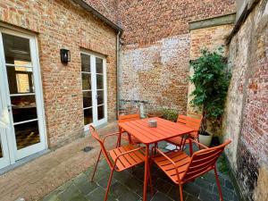 - une table et des chaises rouges sur la terrasse dans l'établissement Clarissa by De Drie Koningen, à Bruges