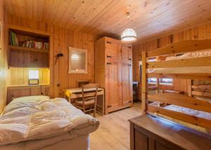 Un dormitorio con una cama, un escritorio y una mesa. en Le Planay, en Notre-Dame-de-Bellecombe