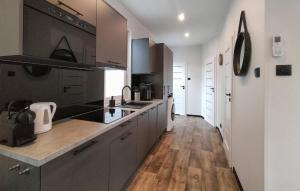 a kitchen with black and white cabinets and wooden floors at 2 Bedroom Gorgeous Home In Hellendoorn in Hellendoorn