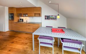 a kitchen with a table and some purple chairs at 3 Bedroom Awesome Apartment In Søgne in Søgne
