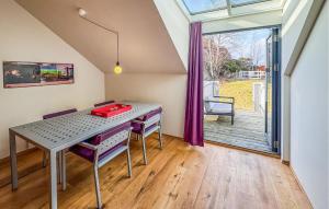 a dining room with a table and a large window at 3 Bedroom Awesome Apartment In Søgne in Søgne