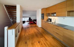 a kitchen with wooden cabinets and a staircase in it at 3 Bedroom Awesome Apartment In Søgne in Søgne