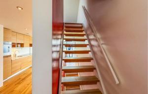 a staircase in a kitchen with a stainless steel wall at 3 Bedroom Awesome Apartment In Søgne in Søgne +8 photos