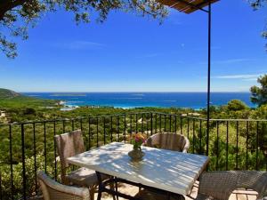 a table and chairs on a balcony with the ocean at Résidence Belvedere de Palombaggia in Porto-Vecchio