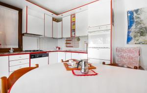 a kitchen with white cabinets and a table with a tea kettle on it at Cozy Home In Torre Dei Corsari in Torre Dei Corsari