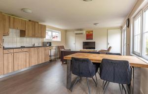 a kitchen and dining room with a wooden table and chairs at 2 Bedroom Stunning Home In Wagenborgen in Wagenborgen