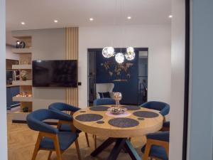 a dining room with a table and blue chairs at Blue Iris, 2BR, Stunning Views, Jacuzzi and Workspace in Sofia +66 photos
