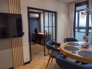 a living room with a dining room table with chairs and a television at Blue Iris, 2BR, Stunning Views, Jacuzzi and Workspace in Sofia