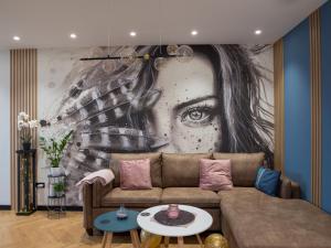 a living room with a couch in front of a mural at Blue Iris, 2BR, Stunning Views, Jacuzzi and Workspace in Sofia
