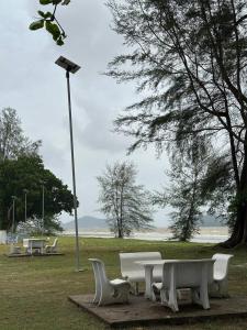a group of white benches in a park with a street light at Homestay D Makmur UNIT 1 in Mersing