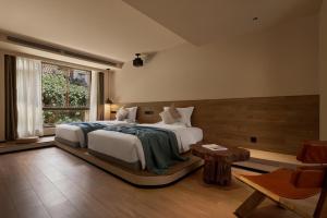 a bedroom with a large bed and a window at LiJiang Garden vacation PuZhi hotel in Lijiang