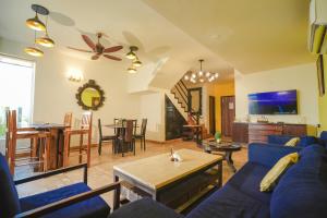 a living room with a blue couch and a table at VILLA M - JIA 3- 3BHK in Candolim, Pool Facing, Near Beach, Breakfast Included in Candolim