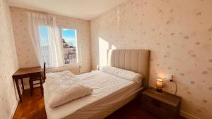 a bedroom with a bed and a desk and a window at Le Centre Bourg, situation rêvée in Saint-Jean-de-Monts