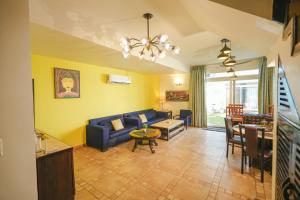 a living room with a blue couch and a table at VILLA M - JIA 3- 3BHK in Candolim, Pool Facing, Near Beach, Breakfast Included in Candolim
