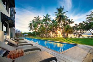 un complejo con piscina con tumbonas y palmeras en Castaways Resort & Spa On Mission Beach, en Mission Beach