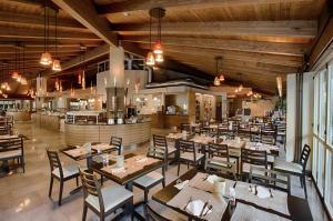 a restaurant with wooden ceilings and tables and chairs at Hotiday Marina di Bibbona in Marina di Bibbona