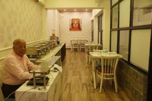 a man sitting at a counter in a restaurant at Subhash Hotel in Prayagraj