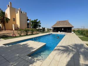 a swimming pool with two people in the water at El oasis Monaco - 3 chambres in Fuente-Álamo de Murcia