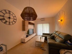 a living room with a couch and a clock on the wall at El oasis Monaco - 3 chambres in Fuente-Álamo de Murcia