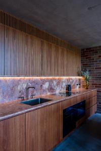 a kitchen with a sink and wooden cabinets at Camperdown - Luxury Architectural Escape in Sydney +52 photos