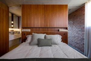 a bedroom with a large bed with a brick wall at Camperdown - Luxury Architectural Escape in Sydney