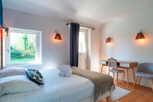 une chambre avec un lit, une fenêtre et un bureau dans l'établissement Kerlavarec - Belle maison avec grand jardin, à Locmariaquer