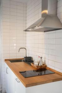 a kitchen counter with a sink and a stove at Casa Bekkevé - Califa Casas in Vejer de la Frontera +5 photos