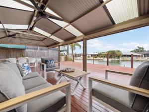 a patio with a couch and chairs on a deck at Canal escape with private jetty and huge deck in South Yunderup