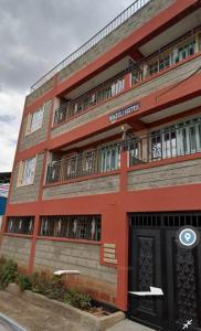 a red brick building with a black door at Angie's Nest in Syokimau