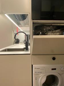 a kitchen with a sink and a washing machine at Modern and compact, Kamppi in Helsinki