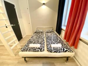 a bed with black and white sheets in a room at Modern and compact, Kamppi in Helsinki