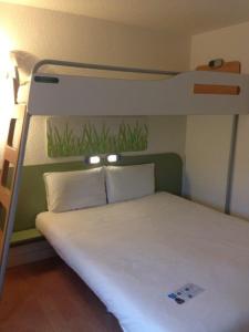 a bed in a room with a bunk bed at Ibis Budget Rambouillet in Rambouillet