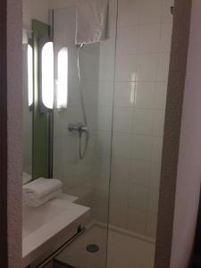 Un baño con ducha con puerta de cristal en Ibis Budget Rambouillet, en Rambouillet 31 fotos más
