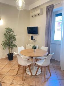 Un comedor con una mesa de madera y sillas blancas. en Urban Oasis in Rome, en Roma 21 fotos más