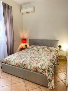 Un dormitorio con una cama con una colcha floral. en Urban Oasis in Rome, en Roma