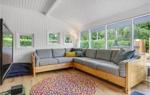 a couch in a living room with windows at Three-Bedroom Holiday Home In Ebeltoft in Ebeltoft