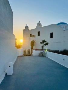 biały budynek z zachodem słońca w tle w obiekcie Villa Kastelli88 Santorini Pyrgos w mieście Pirgos