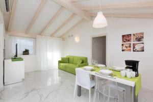 sala de estar con mesa y sofá verde en Residence Klima House de Vilos, en Arco