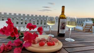 a table with two glasses of wine and a plate of food at L' Atelier, Marpissa Paros in Márpissa +23 photos