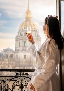 a woman holding a glass of wine in front of a window at Hotel de L'Empereur by Malone in Paris +38 photos