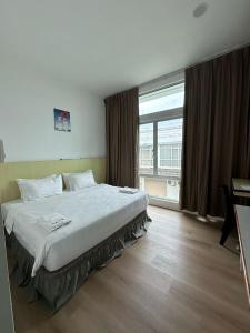 a bedroom with a large bed and a large window at Hotel Jc 118 Sdn Bhd in Sandakan +34 photos