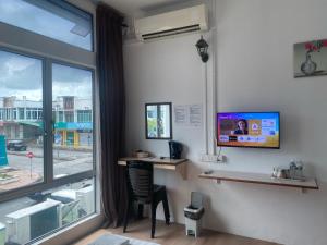 a room with a desk and a tv and a window at Hotel Jc 118 Sdn Bhd in Sandakan