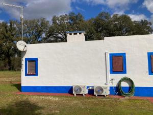 a small white and blue house with two speakers at Ninho das Perdizes - Monte Novo in Cercal