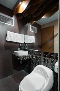 マニラにあるVictoria Court Suites - Pasigのトイレと洗面台付きのバスルーム