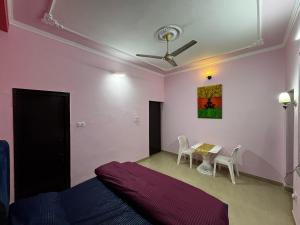a bedroom with a bed and a table with chairs at Vedic Stays Haridwar in Haridwār